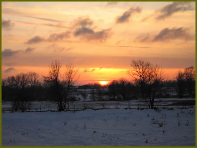 A sunset in winter with fields of snow
